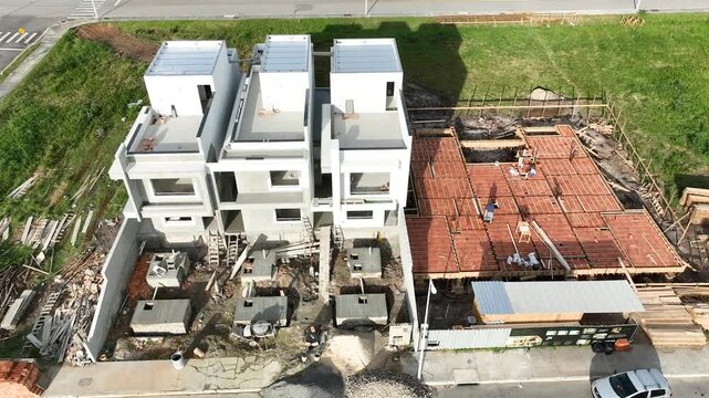 Aerial view of a construction site with workers installing pre-cast concrete and brick flooring for modern housing in Florianopolis, Santa Catarina, Brazil.