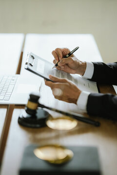 Lawyer reviewing legal documents with a laptop, gavel, and scales of justice, representing legal services, law practice, justice, and professional consultation.