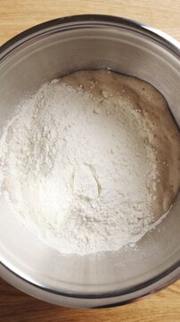 Flour is poured into yeast mix for homemade doughnut dough. Milk, egg, butter and sugar give doughnut dough rich texture. Fry doughnut dough as glazed rings, jam doughnuts or cinnamon twists.