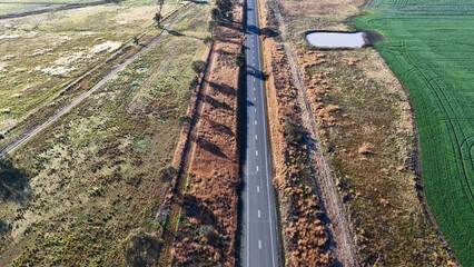 Obraz premium Aerial View of Straight Asphalt Road Through Rural Australian Farmland