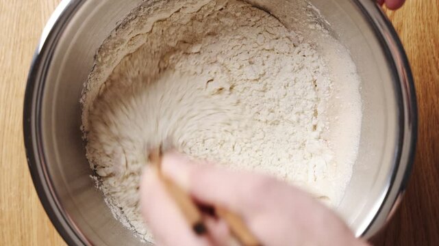 Chef mixes ingredients with chopsticks for gyoza dough. Gyoza dough needs wheat flour, water and salt for elastic wrappers. Roll gyoza dough for pork, chicken, shrimp, mushroom or vegetable dumplings.