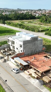 Aerial view of modern residential houses under construction using precast concrete elements with workers on site in Florianopolis, Santa Catarina, Brazil.