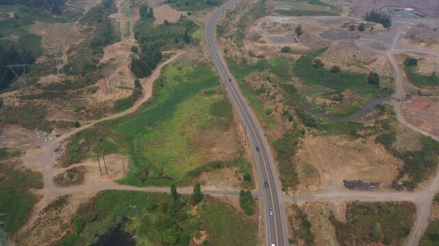 4K aerial drone footage of road through active aggregate quarry near Sherwood, Oregon, USA under heavy smoke from active summer wildfires, highlighting poor air quality, haze and industrial landscape