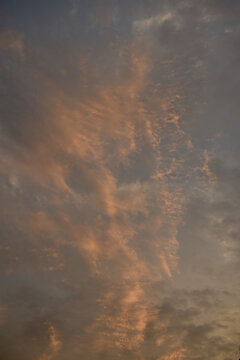 Dramatic orange sunset sky covered with delicate cirrus clouds, creating a warm atmospheric scene with vibrant colors and soft natural light.
