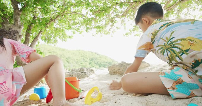 Adorable school child boy and girl enjoy play on white sand sea beach summer vacation travel