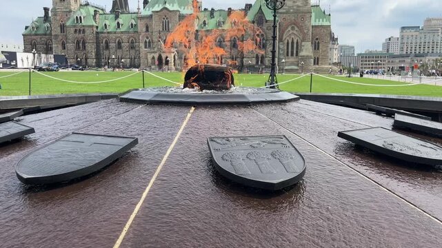 Cinematic pan of Centennial Flame fountain and Ottawa Parliament building