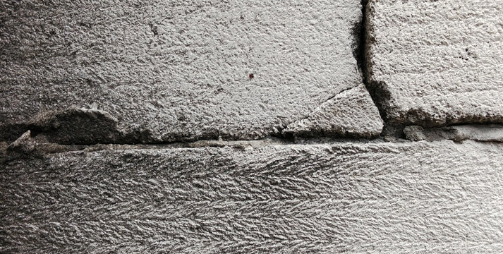 Damaged and cracked concrete block masonry wall texture