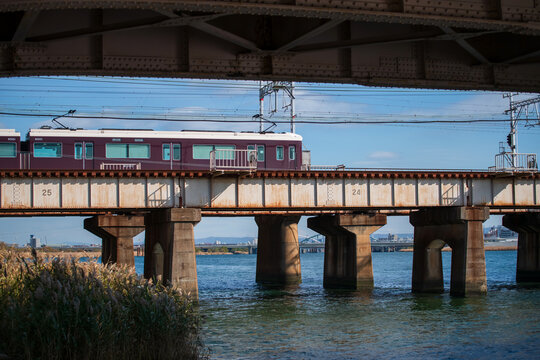 Local train transport on railway across Yodo river, Osaka, Japan