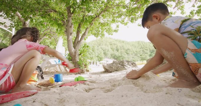 Adorable school child boy and girl enjoy play on white sand sea beach summer vacation travel