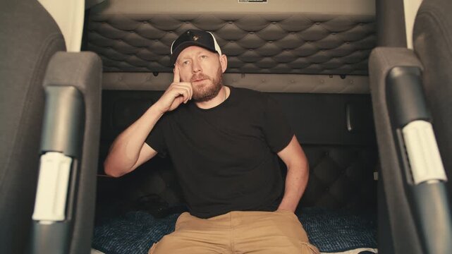 Truck driver thinking during a break in his sleeper cab