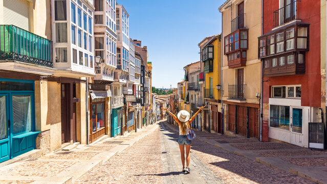 Happy Woman Tourist Standing with Raised Arms in Famous Picturesque Zamora Street Balborraz in Spain
