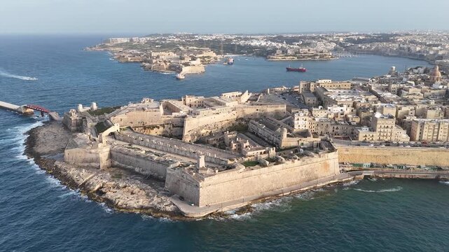 fort st elmo wide aerial view red breakwater bridge ships distant golden hour valletta malta warm evening light coastal fortification peninsula star fort layout limestone rampart view