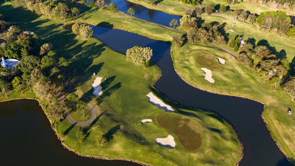 Fototapeta premium Aerial View of Lush Green Golf Course Fairways and Water Hazards