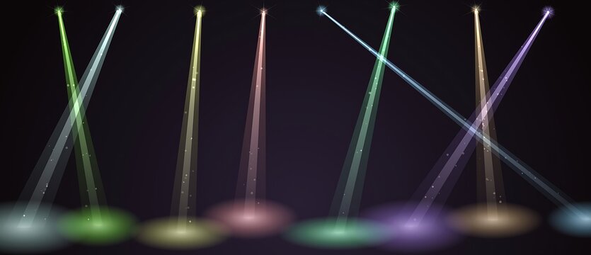 Vertical stage spotlights with colorful light beams crossing on dark background
