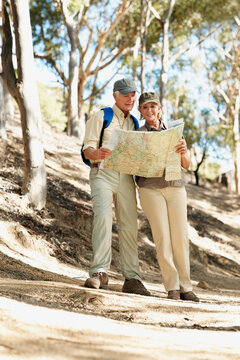 Map, hiking and reading with old couple in nature for trekking, fitness and adventure guide. Wellness, retirement vacation and location search with senior man and woman in forest for travel and trip