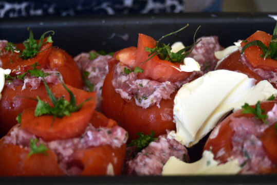 Baking dish filled with homemade stuffed tomatoes ready to be placed in the oven, showing a traditional and appetizing home cooked meal preparation.
