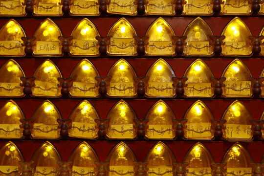 Golden prayer lamps are brightly lit in a Taiwanese temple.