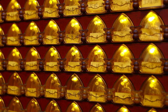 Golden prayer lamps are brightly lit in a Taiwanese temple.