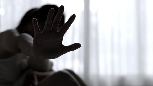 A woman holds up her hand to stop harmful acts against women, representing resistance, victim support, human trafficking awareness, protection, justice, and freedom.