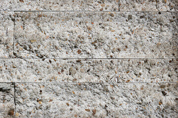 Fototapeta premium Rough terrazzo wall with natural stone aggregate and visible panel joints creates a modern architectural texture for interiors, construction and material design.