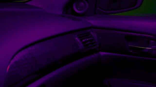 Automobile dashboard illuminated by flashing red and purple lighting