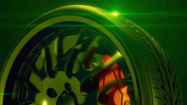 Rotating vehicle tire with alloy rim and orange brake in green light box