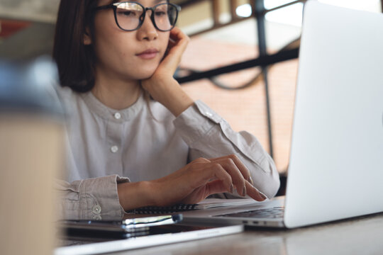 Business person working on laptop and bored in office. Fatigue and tired woman using laptop, browsing the internet. Exhausted employee with depression in workplace