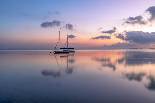 View of the Mar Menor at dawn with two boats on its waters, Punta Prima, Cartagena, Region of Murcia, Spain