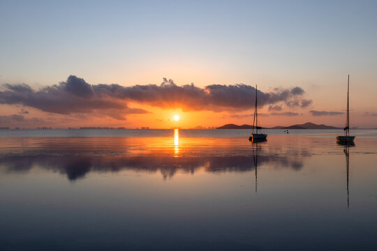 View of the Mar Menor at dawn with two boats on its waters, Punta Prima, Cartagena, Region of Murcia, Spain