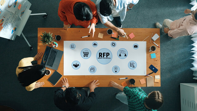 Collaborative Meeting for Request for Proposal (RFP) with Diverse Team Around Conference Table Engaged in Brainstorming Process. Glyphic.