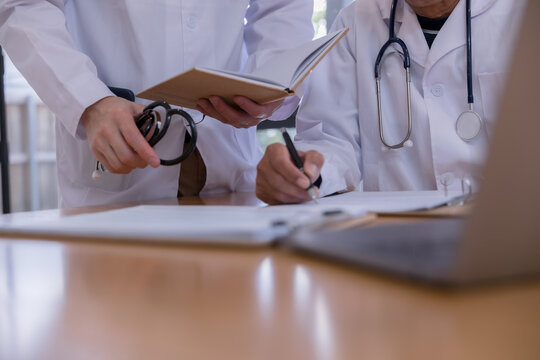 Medical team reviewing digital patient records with tablet and documents in a healthcare clinic. Doctors collaborating with health technology, electronic medical data, AI diagnostics modern clinical