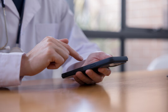 Mobile healthcare healthcare technology and connected care Doctor using smartphone to access patient information in a modern clinic