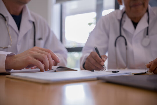 Medical team reviewing digital patient records with tablet and documents in a healthcare clinic. Doctors collaborating with health technology, electronic medical data, AI diagnostics modern clinical