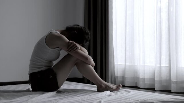 Depressed woman sitting alone, showing emotional pain, sadness and anxiety after psychological abuse, mental trauma and emotional harm, representing a victim struggling with depression.