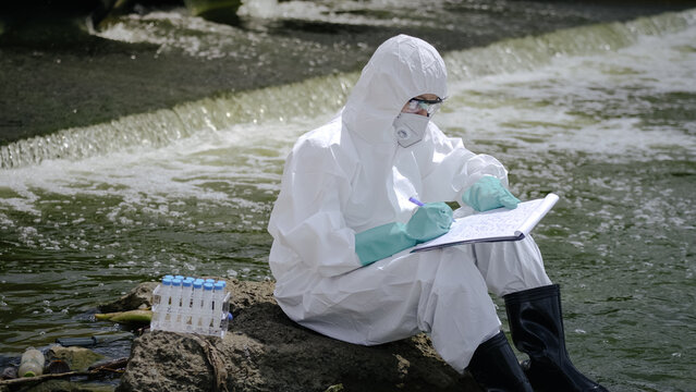 Ecologist Writing Field Inspection Report on Clipboard Outdoors