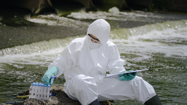 Hazmat Technician Selecting Test Tube from Rack by Wastewater