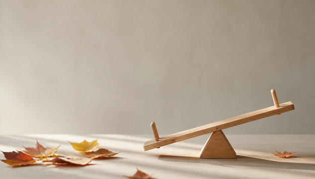 Tiny tilted wooden seesaw model with scattered autumn leaves, balance and prepared practical concept.