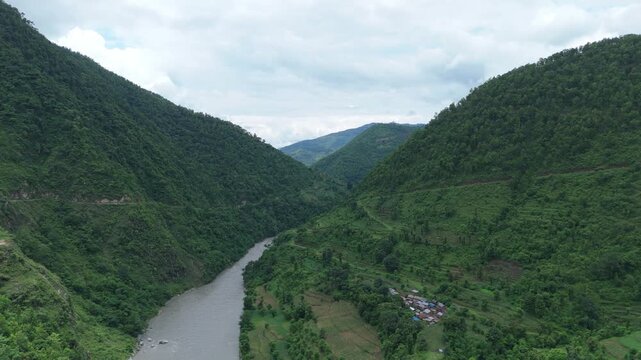 Vast river flowing through deep green V-shaped valley aerial