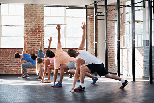 Fitness, workout and together with people in gym for exercise, health and cardio training. Wellness class, athlete and challenge with bodybuilder group for core muscle, stretching and endurance