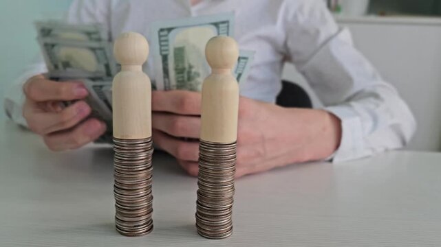 Counting money and stacking coins at a table with wooden figures in an office setting