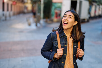 Portrait of a smiling young woman girl walking in the city, tourists visiting destination, summer trip exploring