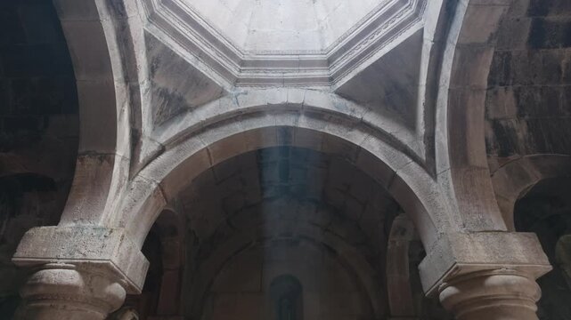 Interior of historic stone building with arched ceilings and central skylight