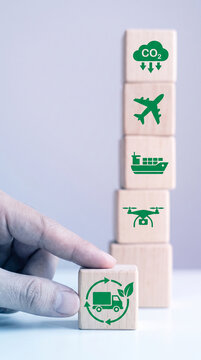Wooden blocks stacked with green transport and CO2 reduction icons, representing sustainable logistics and environmental protection.