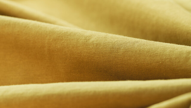 Macro vibrant yellow fabric texture background with selective focus, soft folds, weave patterns, and fine micro-fibers. Perfect for eco-friendly product placement, logo mockups, copy space for text.