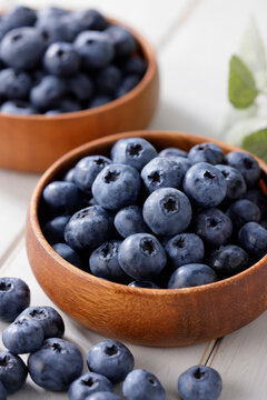 白い木目テーブルに置かれたボウルに入ったブルーベリー　Blueberries in a bowl on a white wooden table