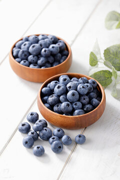 白い木目テーブルに置かれたボウルに入ったブルーベリー　Blueberries in a bowl on a white wooden table