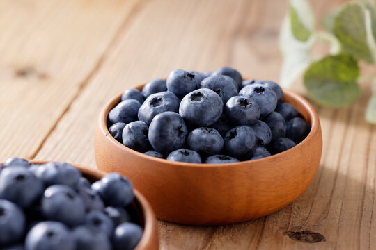 木目テーブルに置かれたボウルに入ったブルーベリー　Blueberries in a bowl on a wooden table