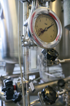 Detailed view of a pressure gauge on a robust stainless steel water preparation and purification system, essential for quality control in a modern pharmaceutical production facility Includes copy spac