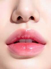 Naklejka premium Close-up of Moist Glossy Lips in a Soft Baby Pink Shade