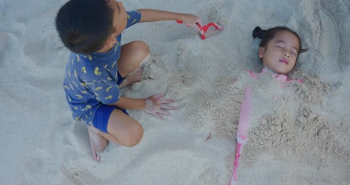 Adorable school child boy and girl enjoy play on white sand sea beach summer vacation travel